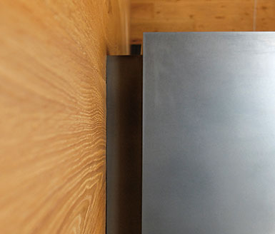 Heizkamin Schwarzstahl Holzwand