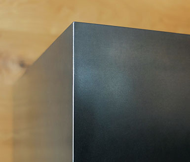 Heizkamin Schwarzstahl Holzwand